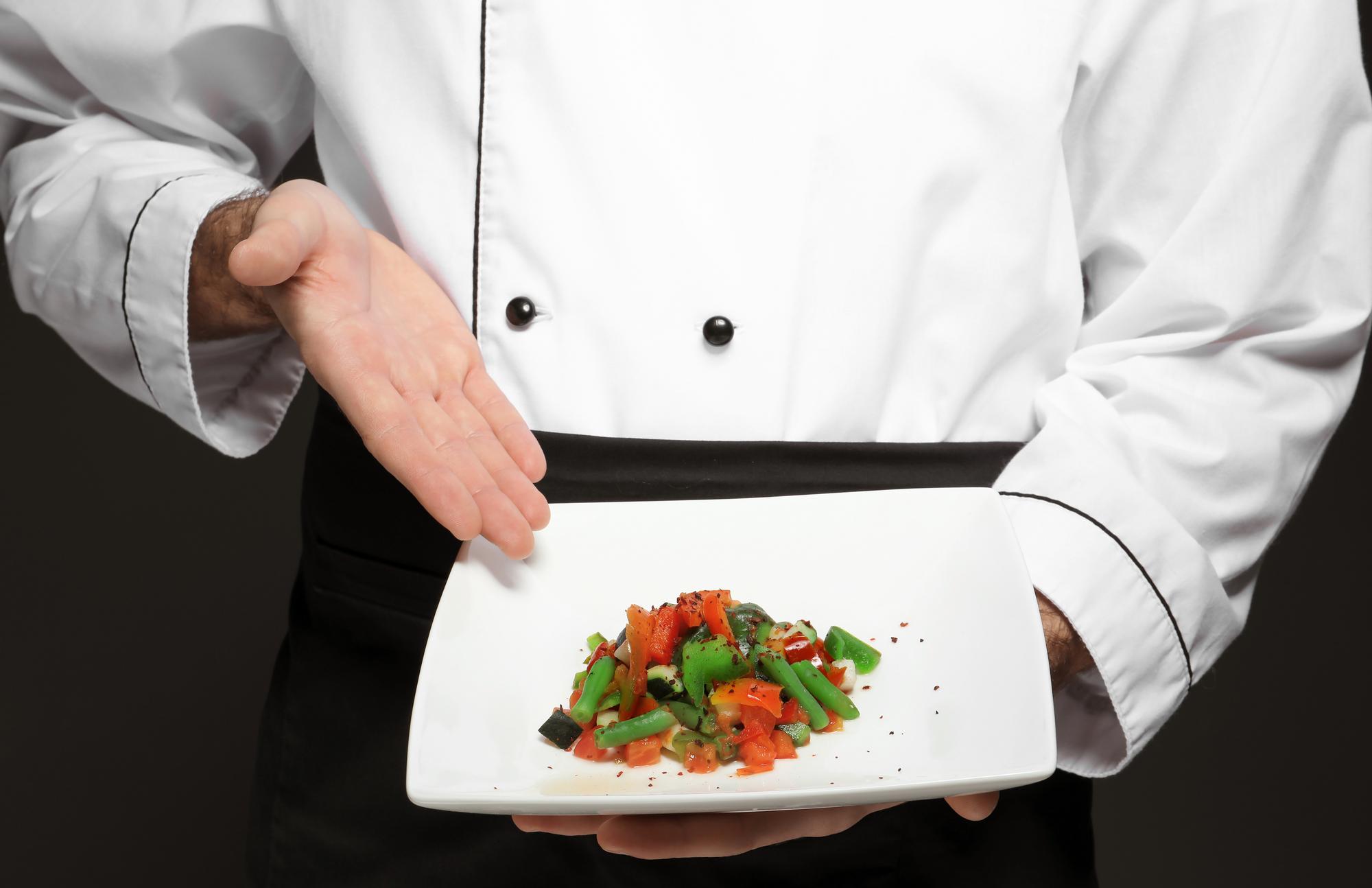 Chef arranging plated course in elegant studio